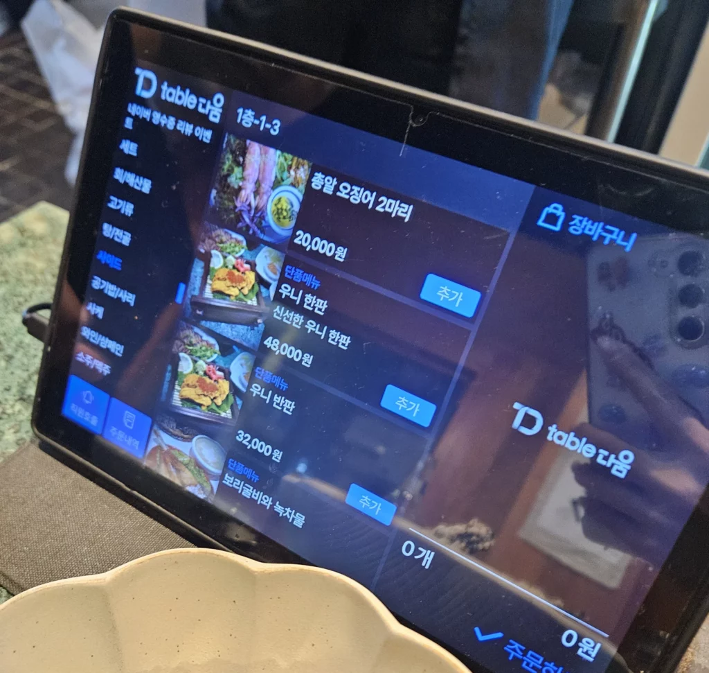 Digital ordering tablet at a Korean style sashimi seafood restaurant in Yongsan showing fresh seafood menu options.