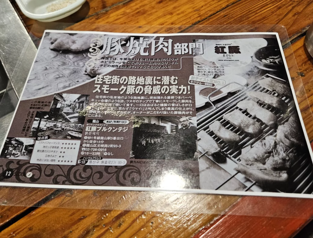 Magazine feature highlighting a hidden smoked K-BBQ restaurant in Yongsan, showcasing charcoal-grilled pork, rustic atmosphere, and the local reputation of this long-running eatery.