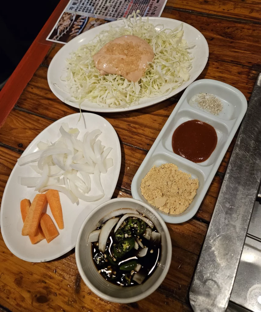 Traditional Korean side dishes and dipping sauces served at a Yongsan restaurant, prepared to accompany rich smoked K-BBQ with fresh vegetables, seasonings, and house-made sauces.