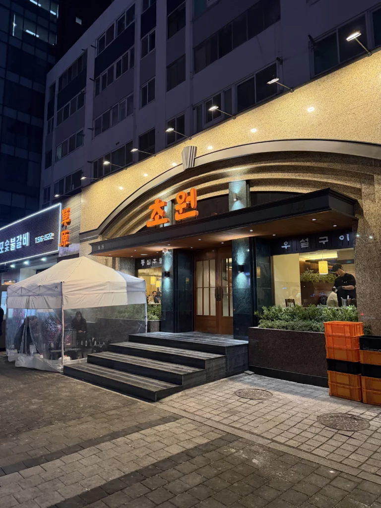 Chowon Korean BBQ restaurant exterior at night in Gangnam Seoul with illuminated golden arch entrance and Korean signage.