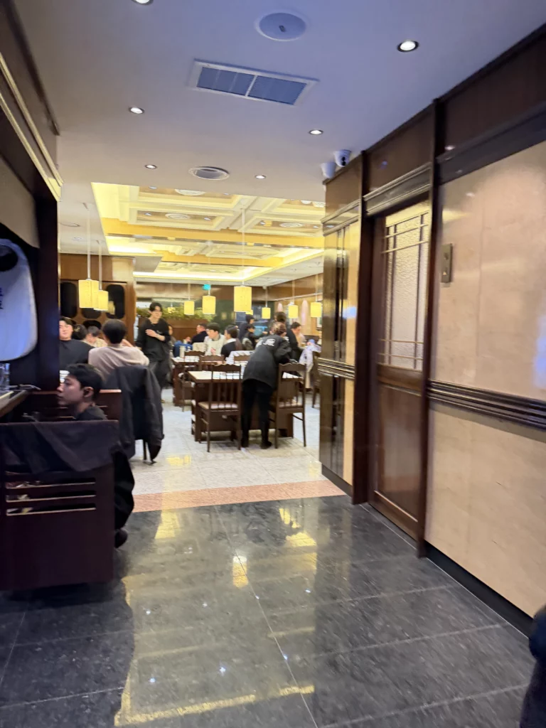 Chowon Korean BBQ restaurant interior dining room in Gangnam Seoul with customers at traditional tables enjoying marinated beef and grilled specialties.