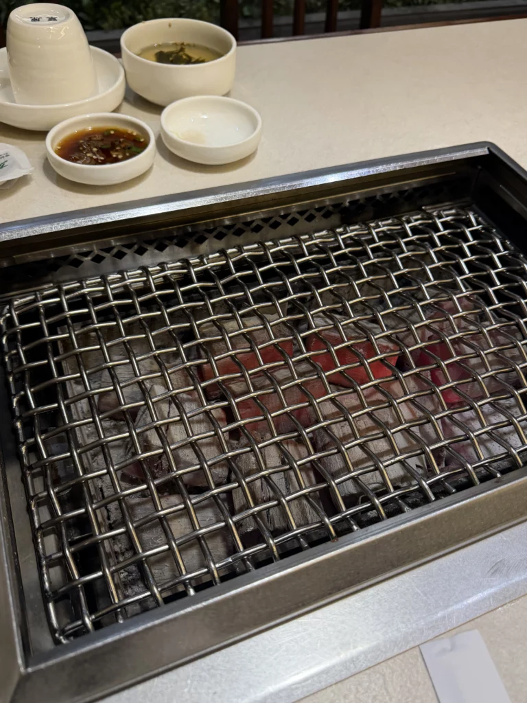 Marinated beef sirloin jumulleok grilling on charcoal grill at Chowon Korean BBQ restaurant in Gangnam Seoul.