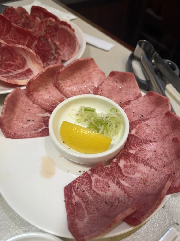 Thinly sliced premium beef tongue arranged around sesame oil and salt dipping sauce at Chowon Korean BBQ in Gangnam Seoul.