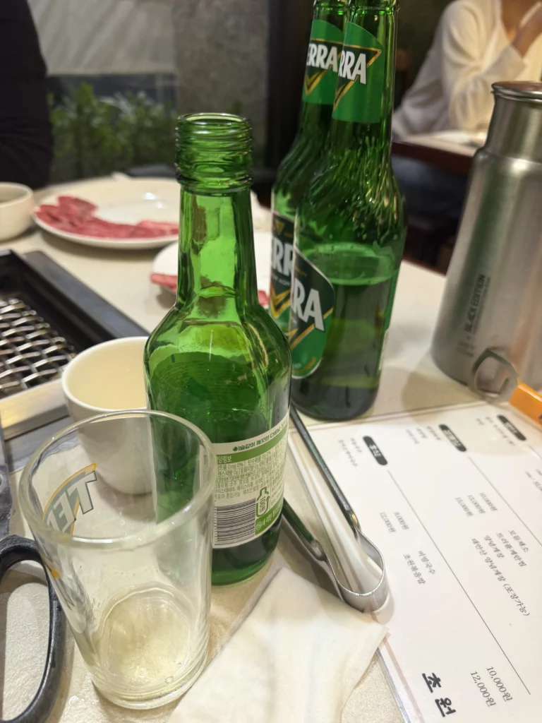 Korean soju bottles and glass on table at Chowon Korean BBQ restaurant in Gangnam Seoul served with grilled beef.