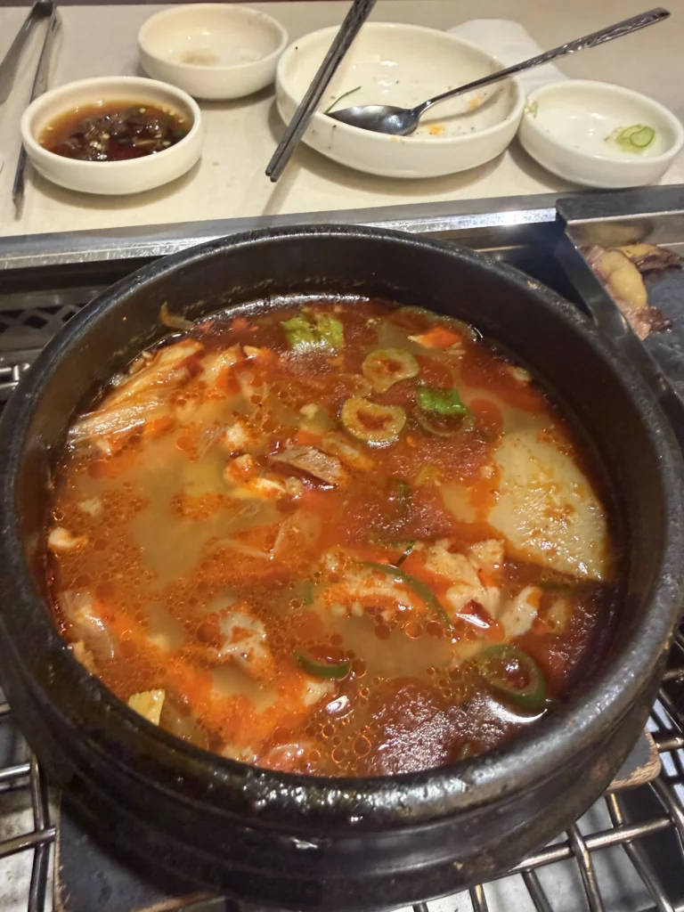 Gopnaejangtang beef tripe and intestine soup simmering in stone pot with scallions as traditional finishing dish at Chowon Korean BBQ in Gangnam Seoul.