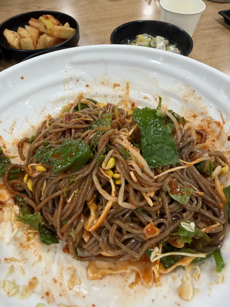 Mixed bibim memil myeon spicy buckwheat noodles with perilla leaves and vegetables at Mijin Michelin Bib Gourmand restaurant in Seoul's Pimatgol district.