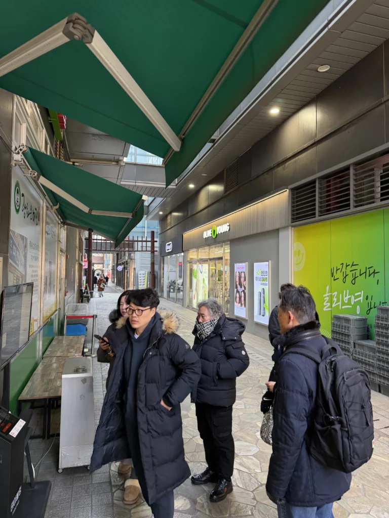 Customers waiting in line during winter at Mijin Michelin Bib Gourmand buckwheat noodle restaurant in Seoul's historic Pimatgol district near Gwanghwamun.