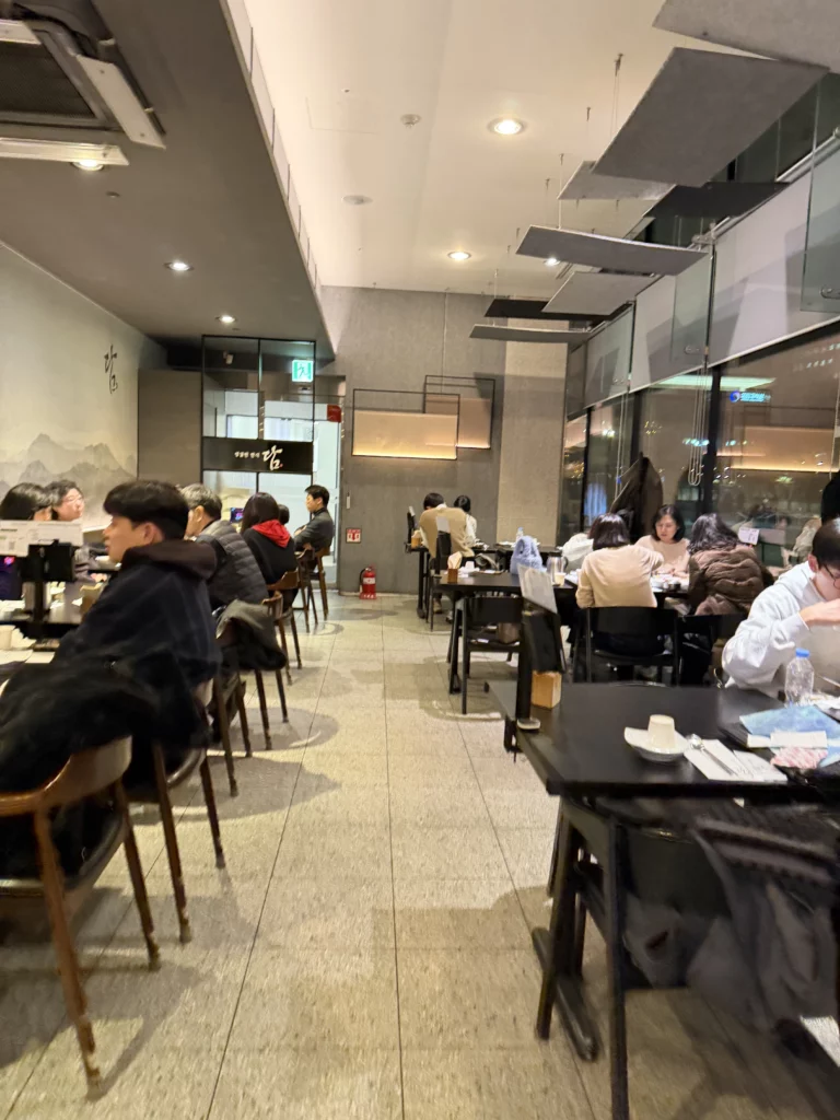 Dam Restaurant interior dining room with customers enjoying traditional Korean hanjeongsik meals at Seoul Arts Center Calligraphy Museum, modern elegant atmosphere for hansangcharim dining in Seocho-gu Seoul.