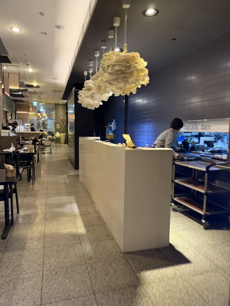 Dam Restaurant interior with modern Korean design featuring artistic cloud-shaped pendant lighting and service counter at Seoul Arts Center Calligraphy Museum for traditional hanjeongsik dining in Seocho-gu Seoul.