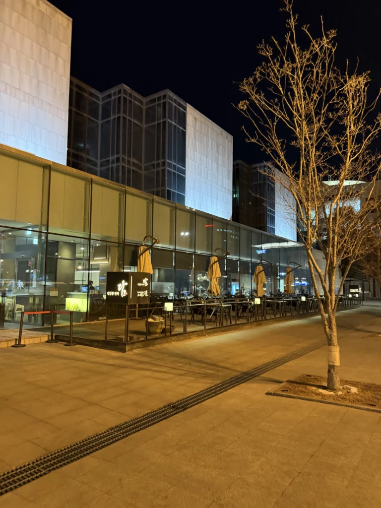 Dam Restaurant outdoor terrace at Seoul Arts Center with illuminated evening dining area and modern glass architecture for traditional Korean hanjeongsik dining in Seocho-gu Seoul.