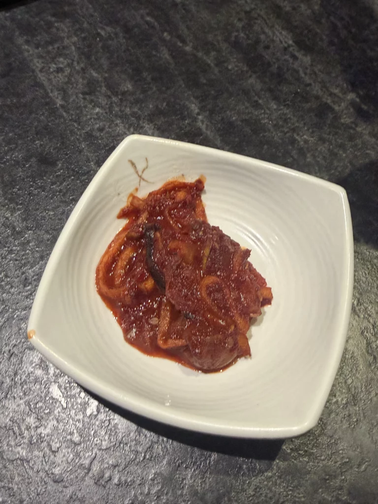 Spicy marinated squid or beef banchan with gochugaru seasoning, traditional Korean fermented side dish from Dam Restaurant hanjeongsik meal at Seoul Arts Center.