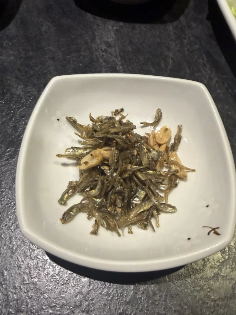 Myeolchi bokkeum stir-fried dried anchovies with nuts in sweet-soy glaze, traditional Korean banchan side dish from Dam Restaurant hanjeongsik meal at Seoul Arts Center.