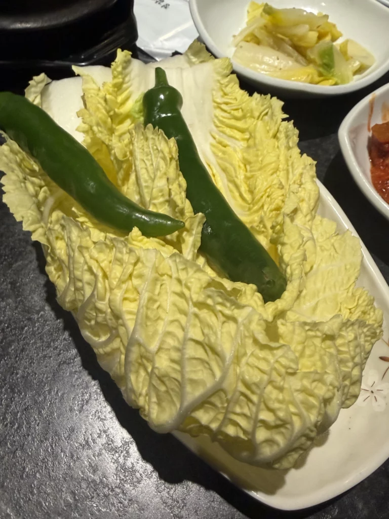 Fresh napa cabbage leaves with green peppers for Korean ssam wraps with bossam pork, traditional banchan from Dam Restaurant hanjeongsik hansangcharim at Seoul Arts Center.