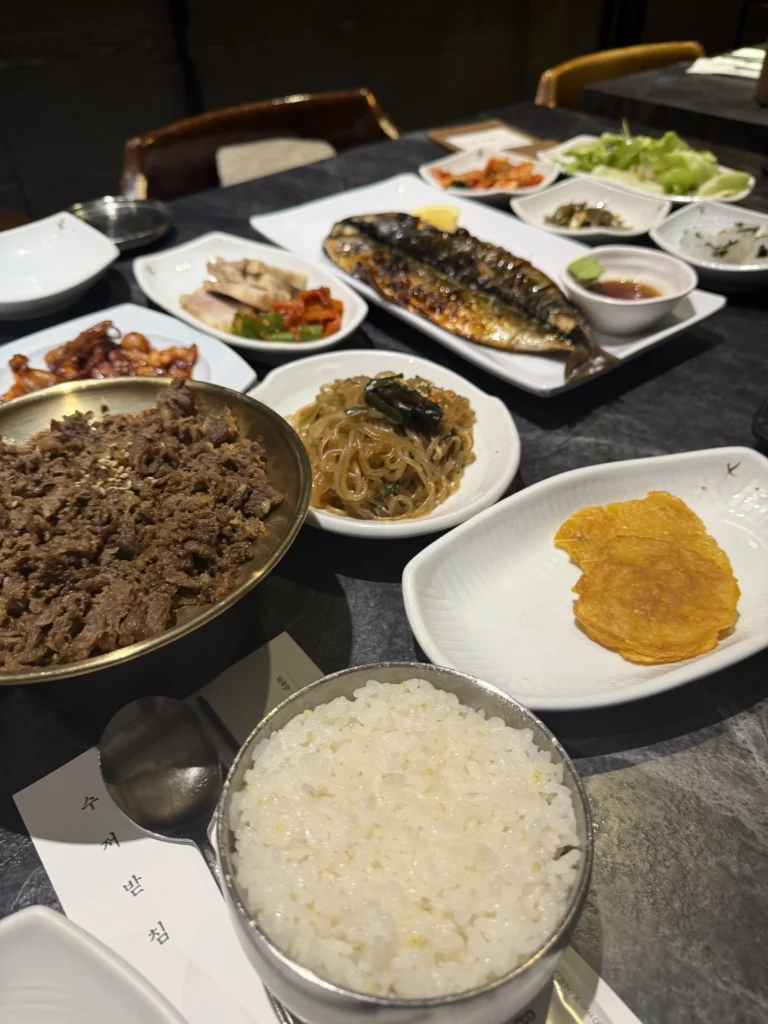Korean hanjeongsik hansangcharim table setting with steamed rice, bulgogi beef, grilled mackerel, japchae noodles, and traditional banchan at Dam Restaurant Seoul Arts Center.