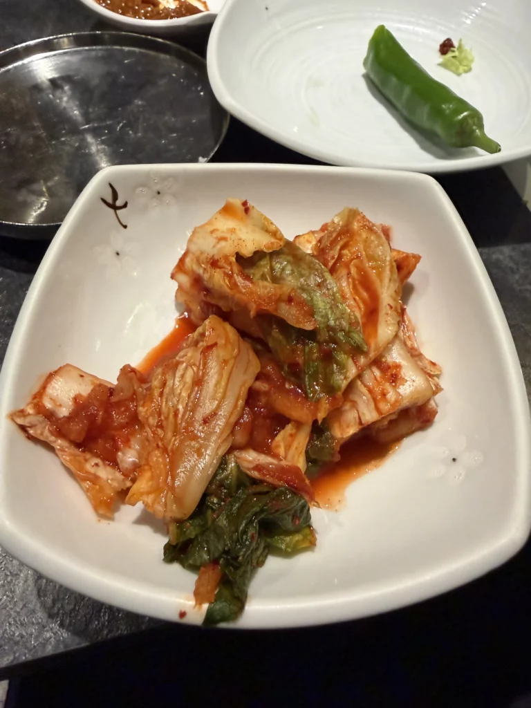 Napa cabbage kimchi baechu kimchi with gochugaru seasoning, traditional Korean fermented banchan side dish served at Dam Restaurant hanjeongsik meal at Seoul Arts Center.