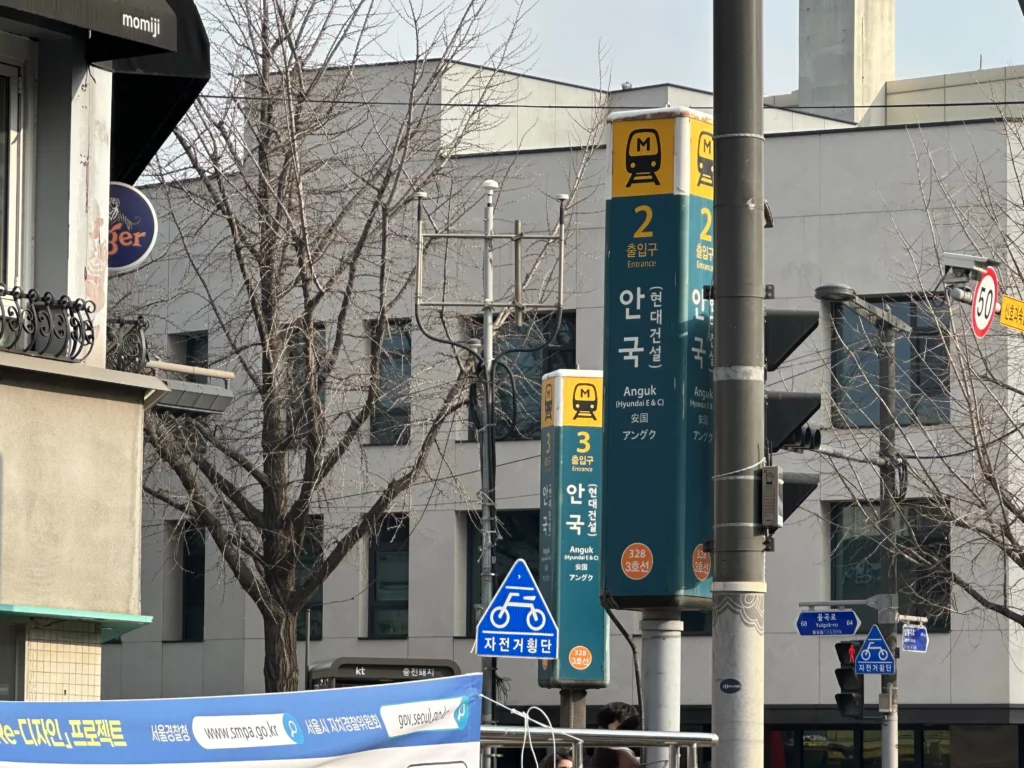 Anguk Station Exit 2 street signs in Seoul, the nearest subway stop to reach Bukchon Son Mandu in Insadong.