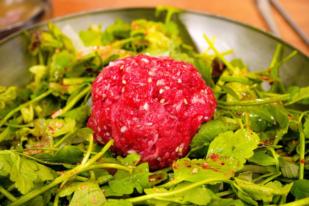 Neungdong Minari fresh Korean water parsley topped with seasoned raw beef (yukhoe) and sesame seeds, a popular Korean minari salad dish.