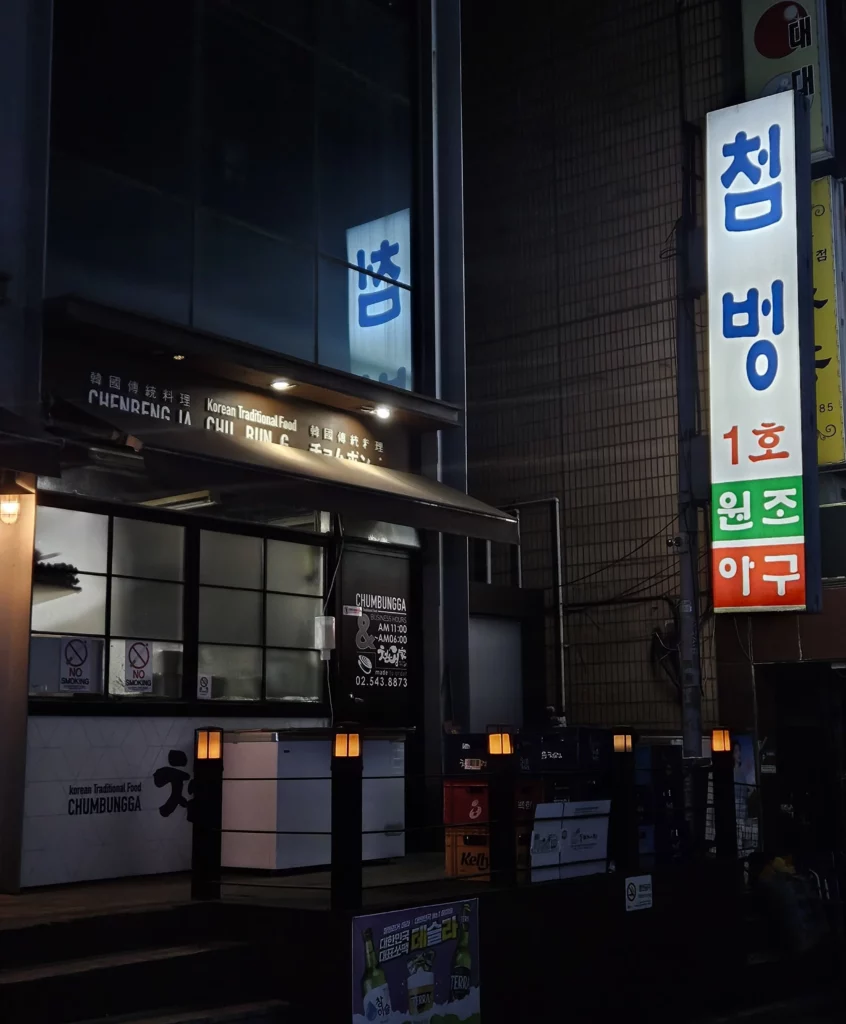 Agujjim: Garosu-gil Braised Monkfish restaurant exterior at night in Garosu-gil, Seoul, featuring the illuminated “Chimbungga” sign and Korean traditional seafood restaurant entrance.