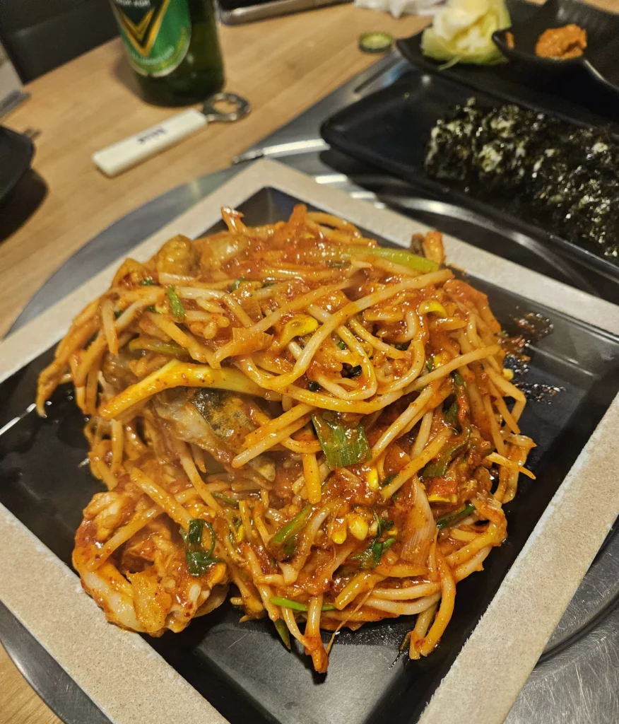 Agujjim: Garosu-gil Braised Monkfish served on a hot plate with spicy red sauce, bean sprouts, green onions, and tender monkfish pieces at a Korean seafood restaurant in Garosu-gil.