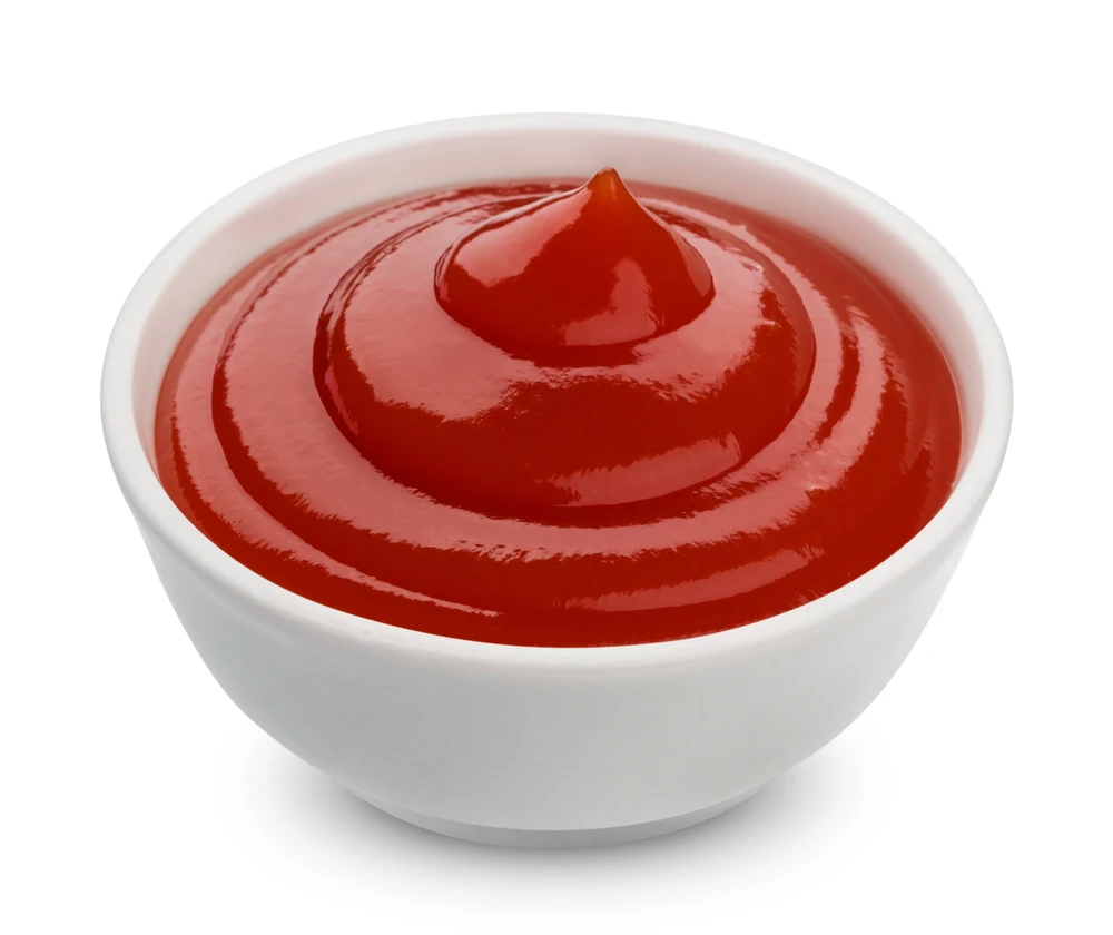 Smooth red ketchup swirled in a white bowl, the tangy condiment essential to Korean street toast's sweet-savory balance.