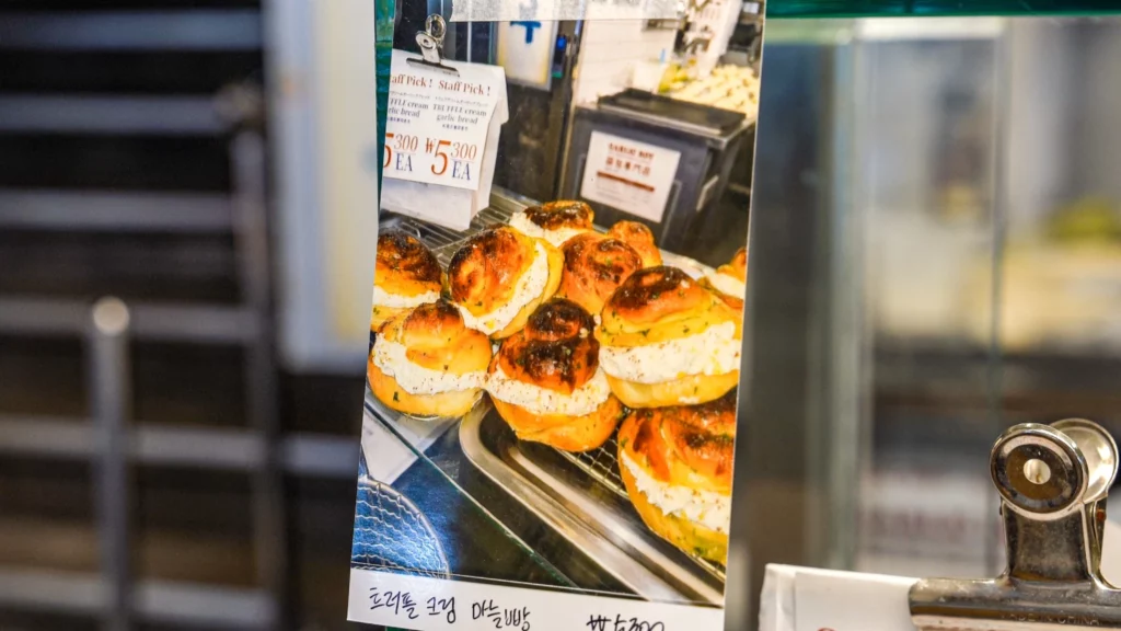 Garlic Boy in-store display card showing a tray of truffle cream garlic bread labeled 