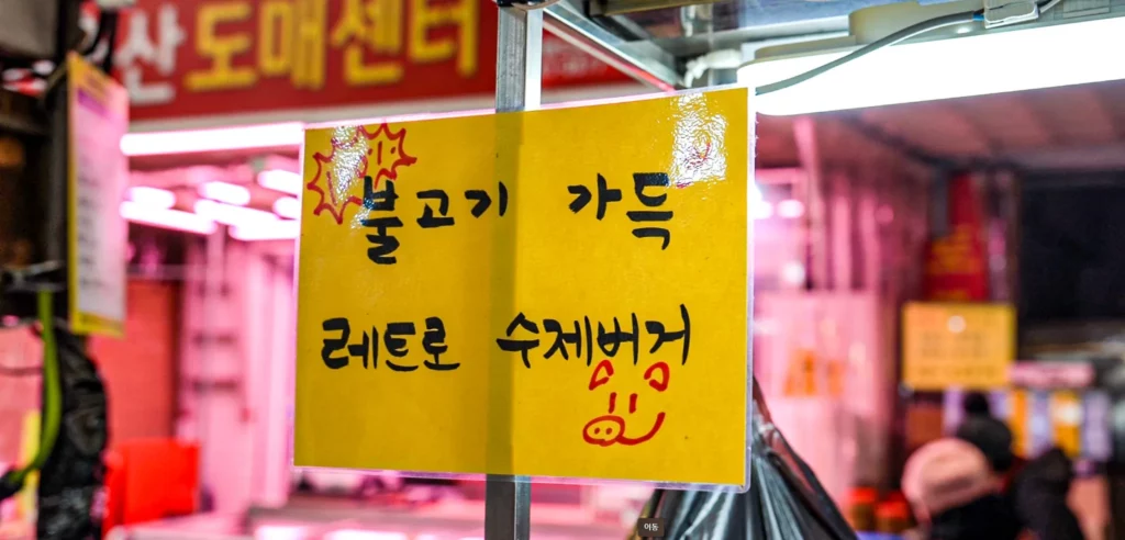 Handwritten yellow sign at Samdeok Burger announcing bulgogi-packed retro handmade burgers.