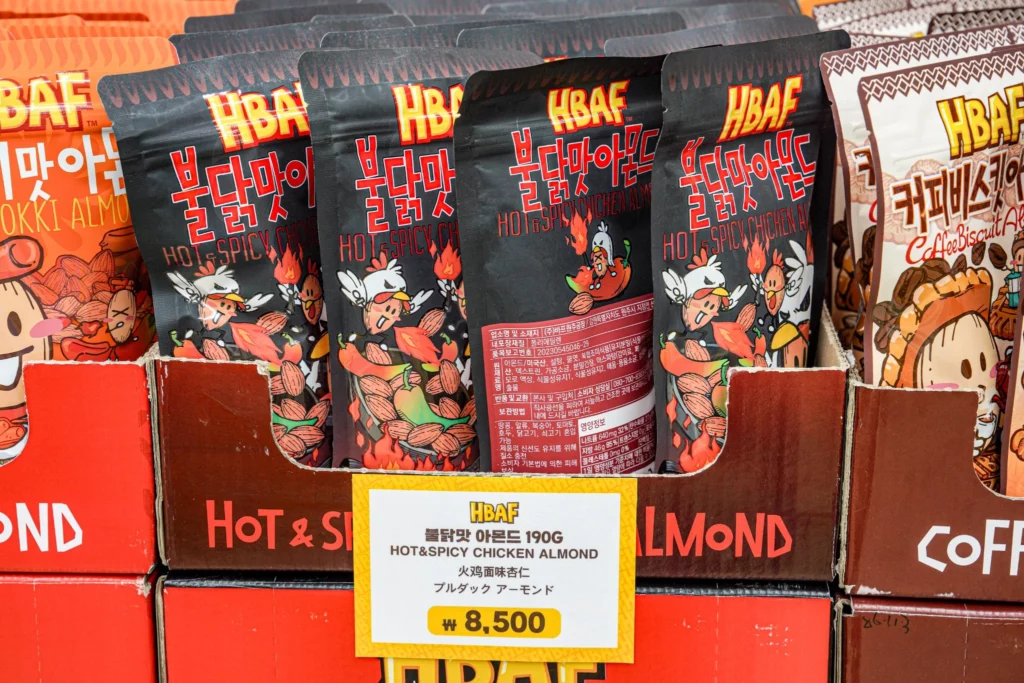 HBAF Hot & Spicy Chicken Almond 190g buldak-flavor pouches in black packaging priced at ₩8,500 on the display shelf.