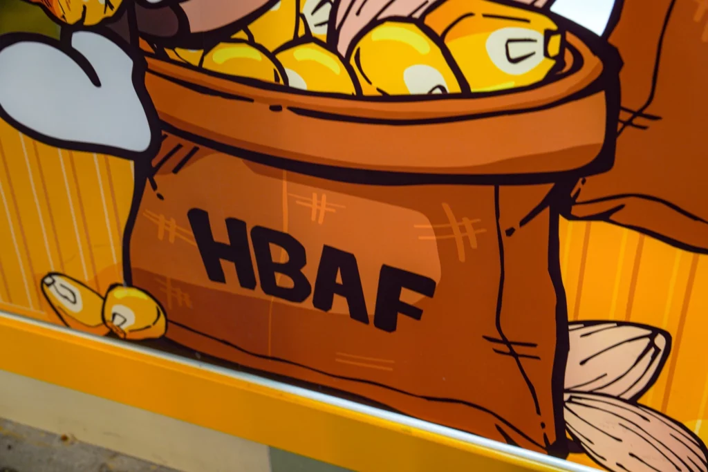 Close-up wall mural at HBAF Almond Store showing a cartoon sack of almonds with the HBAF logo in bold black letters.