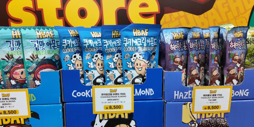 HBAF Cookie & Cream Almond 190g pouches displayed between Laver Almond and Hazelnut Bong Bong varieties on blue boxes.
