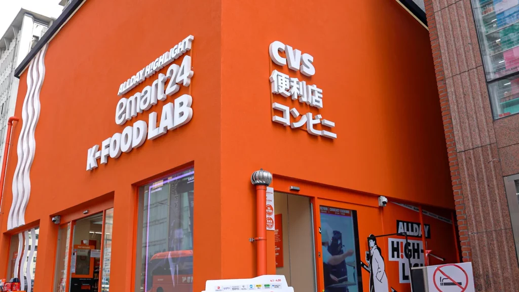 Close-up of the orange Emart24 K-Food Lab Myeongdong facade featuring 
