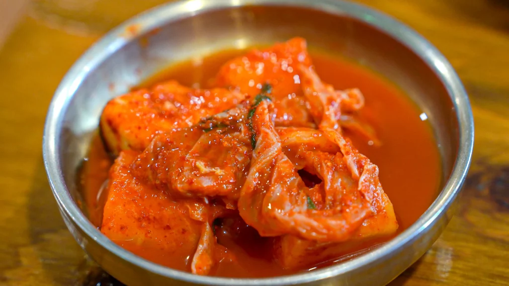 Hadongkwan's signature kkakdugi cubed radish kimchi in a brass dish, the only banchan served with the gomtang.