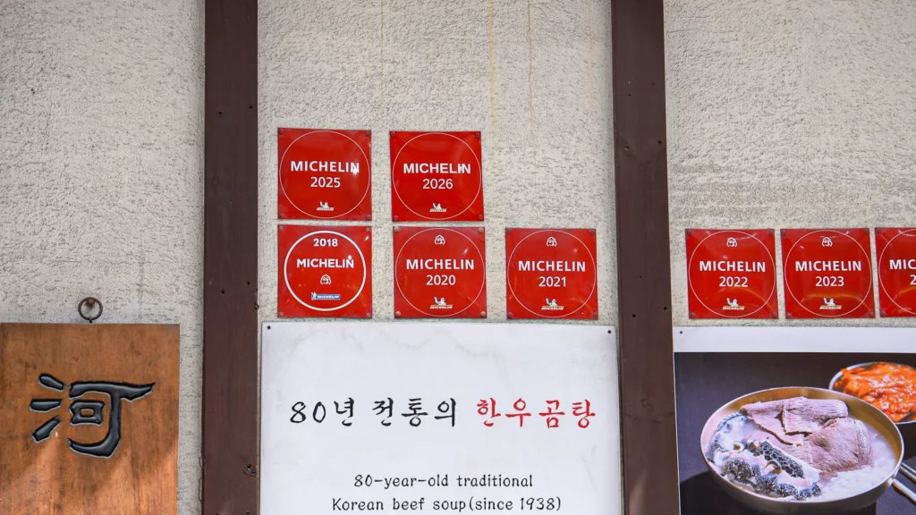 Michelin Guide 2018–2026 plaques on Hadongkwan's wall above a sign for the 80-year-old traditional Korean beef soup since 1938