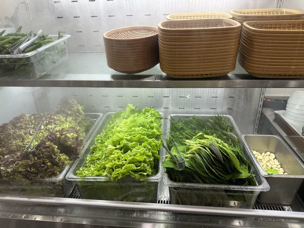 Fresh perilla leaves and lettuce for ssam wraps prepared at this BTS favorite Jeju restaurant.
