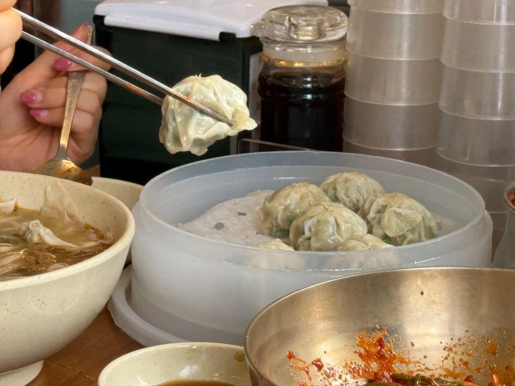 Stainless steel bowl of Myeongdong Kyoja's famously garlic-heavy kimchi, the unlimited self-serve side for kalguksu.