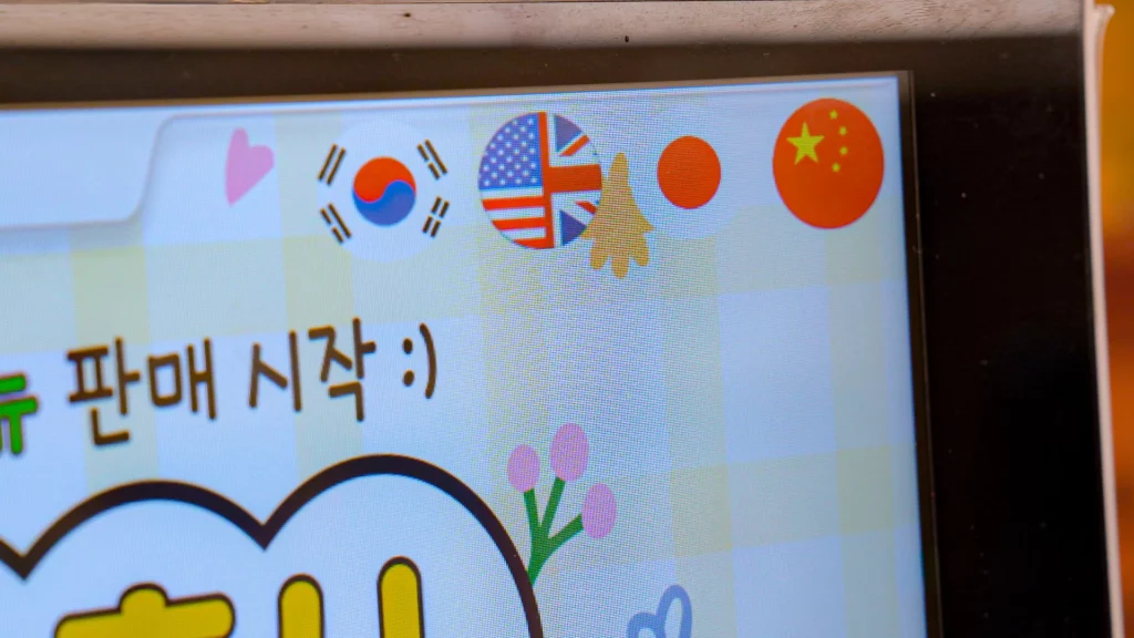 Self-service kiosk screen at chickgimbap Myeongdong showing Korean, English, Japanese, and Chinese language flag options.