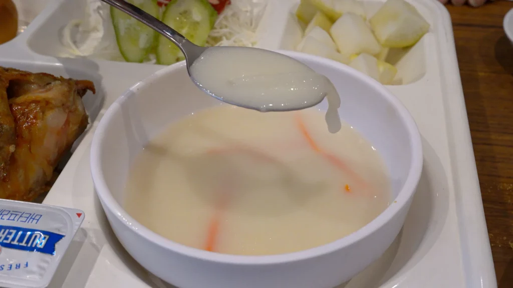 Spoonful of creamy chicken broth soup served as part of the Yeongyang Center Myeongdong tongdak lunch set.