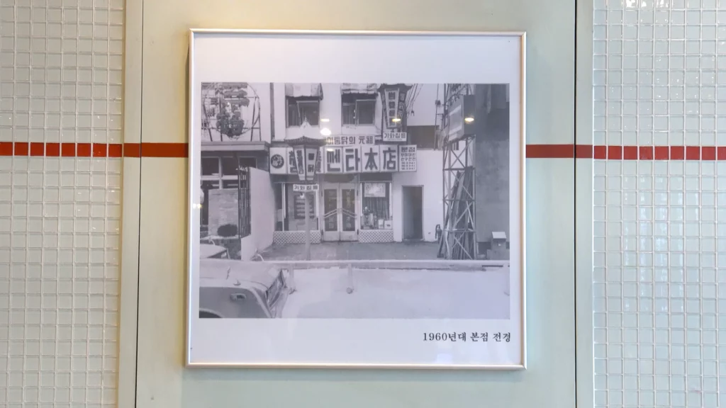 Framed black-and-white photo of the original 1960s Yeongyang Center Myeongdong tongdak storefront, captioned